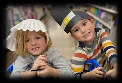 Two students wearing pilgrim hats, bringing American history to life
