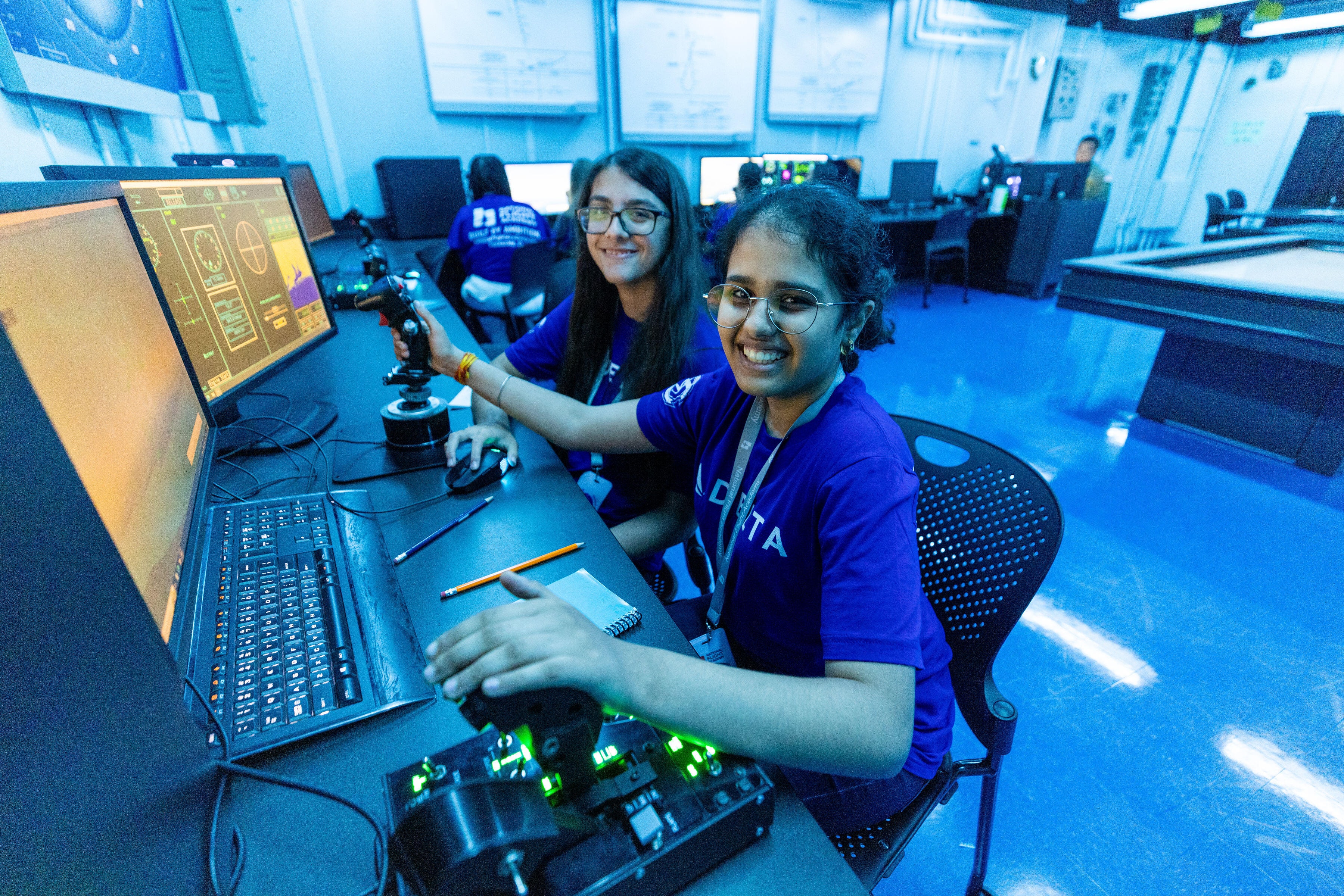 Students working in an aviation technology lab with flight simulators